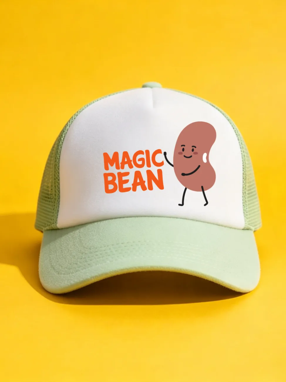 Sage green trucker cap with a white front panel, orange MAGIC BEAN lettering and a cartoon bean character on a yellow background