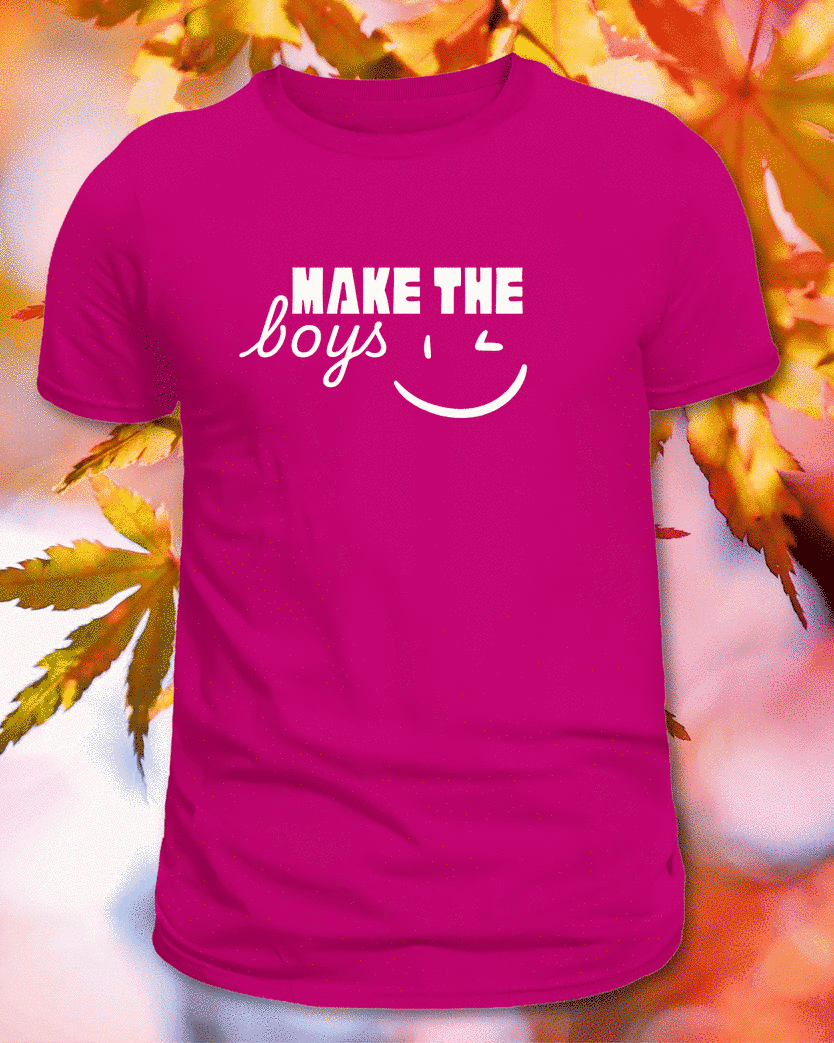 Pink T-shirt printed with white Make the Boys Wink lettering, photographed against autumn leaves